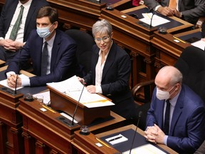 Generalstaatsanwalt David Eby (links) und Premier John Horgan sehen zu, wie Finanzministerin Selina Robinson am Dienstag, den 22. Februar 2022, die Haushaltsrede in der gesetzgebenden Versammlung der Legislative in Victoria, BC, hält.