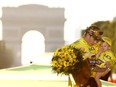 Danish cyclist Jonas Vingegaard, with his daughter Frida, celebrates on the podium in Paris after winning the Tour de France on July 24, 2022.