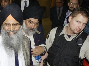 16. März 2005. Der Richter im Bombenanschlagsverfahren von Air India befand Ripudaman Singh Malik (links) des Bombenanschlags auf Air India Flug 182 für nicht schuldig. Er wird von einem Gerichtssheriff und einem unbekannten Mann zu einem wartenden Auto eskortiert.