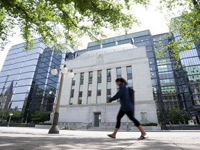 A woman walks past the Bank of Canada headquarters, Wednesday, June 1, 2022 in Ottawa.