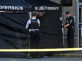 Police set up a forensics tent in the parking lot next to the Mission Thrift Shop on Logan Ave. and Glover Road.