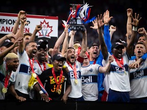 Vancouver Whitecaps' Russell Teibert, centre, hoists the Voyageurs Cup after Vancouver defeated Toronto FC in penalty kicks during the Canadian Championship soccer final, in Vancouver, on Tuesday, July 26, 2022.