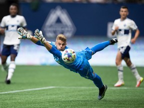 Vancouver Whitecaps goalkeeper Isaac Boehmer dives for the ball as it gets past him but bounces off the post and stays out of the goal during the first half of an MLS soccer game against the Chicago Fire in Vancouver, on Saturday, July 23, 2022.