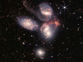 A group of five galaxies that appear close to each other in the sky: two in the middle, one toward the top, one to the upper left and one toward the bottom are seen in a mosaic or composite of near and mid-infrared data from NASA's James Webb Space Telescope, a revolutionary apparatus designed to peer through the cosmos to the dawn of the universe.