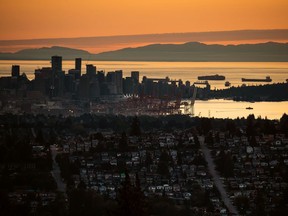 The sun sets over downtown Vancouver and the Burrard Inlet on Monday, July 11, 2022. Temperature records are melting across British Columbia as a prolonged heat spell grips the province but Emergency Management BC says it is not anticipating an extreme heat emergency.THE CANADIAN PRESS/Darryl Dyck