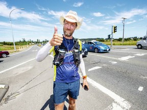 Dave Proctor, a 41-year-old massage therapist from Okotoks, Alta., gives a thumbs up on the Pat Bay Highway near Mount Newton Cross Road Thursday after running from St. Johns, Nfld. in 67 days and 10 hours.
