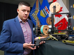 Staff Sgt. Ben Lawson of the Calgary Police Service displays the 3D-printed guns that were confiscated in a recent investigation.