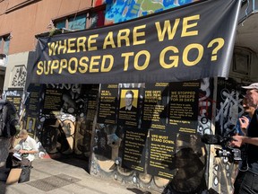 Posters were pasted behind the podium at the Balmoral Hotel in Vancouver for a press conference at Hastings Tent City on August 16, 2022.
