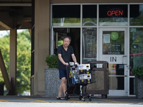 A person leaves a government-run BC Liquor Store with a cart full of purchases in Vancouver, on Friday, August 19, 2022. British Columbia's Finance Ministry says government-run liquor stores are implementing limits on alcohol sales in response to job action affecting several distribution outlets, effective immediately.