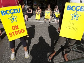 Des grévistes sont vus au centre-ville de Vancouver lors d'une grève de plus de 27 000 employés du gouvernement de la Colombie-Britannique le 5 septembre 2012. Le syndicat représentant environ 33 000 employés de la BC Public Service Agency a émis un préavis de grève à l'employeur du gouvernement.