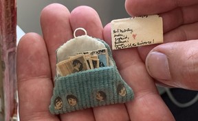 A close-up of Reid Shier holding a quilt with tiny Beatles lyrics in his hand.  The letter is addressed to 