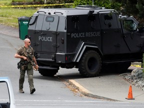 A police officer looks on after two gunmen who entered a bank were killed in a shootout with police in Saanich, British Columbia, Canada, June 28, 2022. REUTERS/Kevin Light