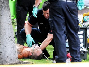 Sanitäter neigen zu Larry Ronald Amero nach einer Schießerei vor dem Delta Grand Hotel in Kelowna, BC, am 14. August 2011. Jonathan Bacon wurde erschossen.  Fünf weitere wurden ins Kelowna Hospital gebracht.