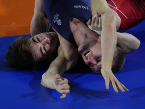 Canada's McNeil Lachlan, left, wrestles with Scotland's Connelly Ross during Men's freestyle match at the Commonwealth Games, in Birmingham, England, Friday, Aug. 5, 2022.