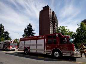 A firefighter returns to a truck after crews extinguished a 3-alarm fire at an apartment building in Burnaby, B.C., on Tuesday May 27, 2014. The union that represents E-Comm 911 emergency service dispatchers in British Columbia is calling for the agency to extend temporary compensation and psychological supports amid a "dire" staffing shortage.THE CANADIAN PRESS/Darryl Dyck