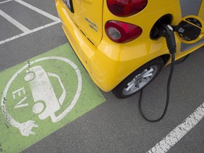 A electric car is seen getting charged at parking lot in Tsawwassen, near Vancouver B.C., Friday, April, 6, 2018.