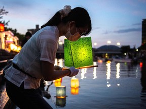 People release paper lanterns on the Motoyasu River beside the Hiroshima Prefectural Industrial Promotion Hall, commonly known as the atomic bomb dome, to mark the 77th anniversary of the world's first atomic bomb attack in Hiroshima on August 6, 2022.