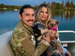 Juan Carlos La Verde, wife Christine, and their dogs. La Verde is in ICU after he was bitten in the face by an alligator while swimming in a lake.