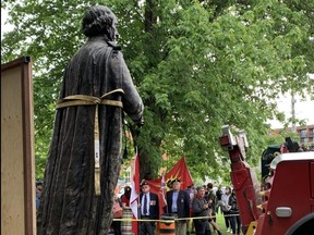 Work crews remove a statue of Canada's first prime minister Sir John A. Macdonald from City Park in downtown Kingston, Ont., where it has stood since 1895, on Friday, June 18, 2021.