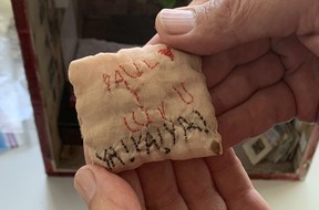 A close-up of Reid Shier of Polygon Gallery holding in his hand a small pillow that says a fan's love for Paul McCartney.