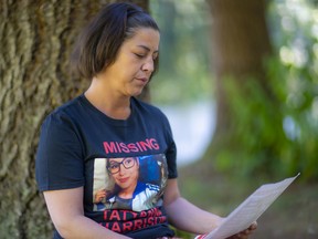 Natasha Harrison studies the poster of her 20-year-old daughter, Tatyanna, who went missing on the Downtown Eastside last spring.