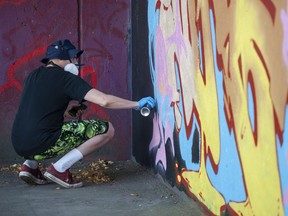 Der Graffiti-Künstler Virus arbeitet am Samstag beim Holden Courage Graffiti Jam im Rahmen des Vancouver Mural Festival in Vancouver an einer Kreation.