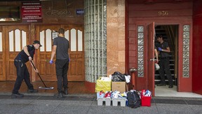A work crew cleans up after a machete attack at a rooming house next door to The Roxy nightclub in Vancouver’s Granville entertainment district on Saturday night.