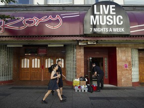 A work crew cleans up after a machete attack at a rooming house next door to The Roxy nightclub in Vancouver’s Granville entertainment district on Saturday night.