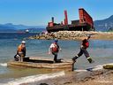 Arbeiter sind vor dem verfallenen Lastkahn in der English Bay in Vancouver zu sehen, als Anfang August mit der Demontage begonnen wird.  Die Arbeiten sollten zwischen 12 und 15 Wochen dauern.