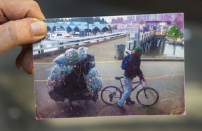 Recycler Michael Leland holds up a photo of himself from five years ago on his route near the Royal Vancouver Yacht Club.