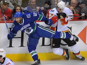 Prab Rai hits hard against Lance Bouma of the Calgary Flames during a preseason game at Rogers Arena in 2010.