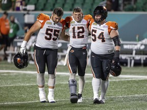 B.C. Lions quarterback Nathan Rourke is helped off the field with an injured foot in Regina against the Saskatchewan Roughrider on Friday, Aug. 19.