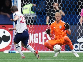 Vancouver Whitecaps' Ryan Gauld, left, scores his second goal of the game against Colorado Rapids goalkeeper William Yarbrough during the first half of an MLS soccer game in Vancouver on Wednesday, August 17, 2022.