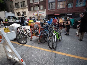 Die Sachen einer Person werden auf die Straße gestellt, um eingelagert zu werden, nachdem ihr Zelt am Dienstag, den 9. August 2022, in einem weitläufigen Obdachlosenlager in der East Hastings Street in der Innenstadt von Vancouver vom Bürgersteig geräumt wurde.