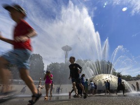 The International Fountain at Seattle Center is packed with children as they run from the water that is showering on them Wednesday, July 27, 2022 in Seattle.
