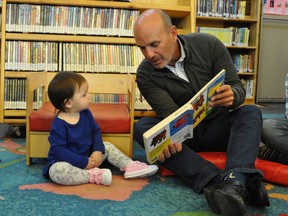 B.C.'s Municipal Affairs Minister Nathan Cullen reads to a toddler during a promotion for The Vancouver Sun's Raise-a-Reader campaign.