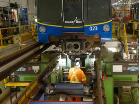 TransLink vehicle technician Dale Chupik works on machining a wheel under a SkyTrain car at the company's Burnaby facilities on Wednesday.