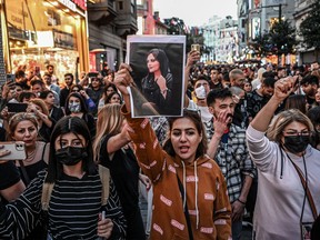 A protester holds a portrait of Mahsa Amini  during a demonstration in support of Amini, a young Iranian woman who died after being arrested in Tehran by the Islamic Republic's morality police, on Istiklal avenue in Istanbul on September 20, 2022.