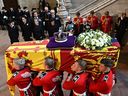 The coffin of Queen Elizabeth II is carried past members of the Royal family into Westminster Hall on Sept. 14. The Queen will lie in state in Westminster Hall until her funeral on Monday.