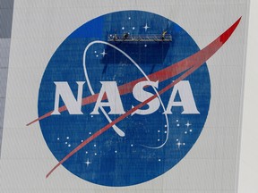 Workers pressure wash the logo of NASA on the Vehicle Assembly Building at the Kennedy Space Center in Cape Canaveral, Florida, May 19, 2020.