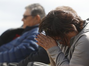 A woman prays during a news conference by officials at the James Smith Cree Nation on Sept. 8. On Sept. 7, the RCMP reported that Saskatchewan stabbing suspect Myles Sanderson had died in police custody.
