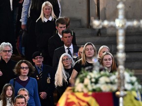 Members of the public pay their respects as they pass the coffin of Queen Elizabeth II as it Lies in State inside Westminster Hall, at the Palace of Westminster in London on Sept. 17, 2022.