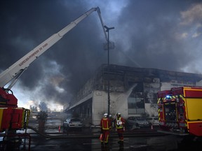 Firefighters work to put out a fire in a building at the "Rungis International Market" wholesale food market in Rungis, south of Paris, on September 25, 2022.