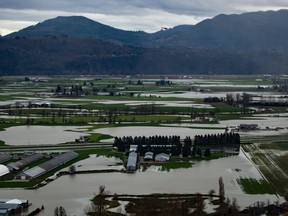 A helicopter flies over flooded farmland in Abbotsford, B.C., on Wednesday, December 1, 2021. The City of Abbotsford is getting a funding boost from the B.C. government to help ensure its drinking water system will withstand extreme weather and climate-related disasters.