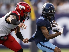 Calgary Stampeders linebacker Cameron Judge (4) tugs on the jersey of Toronto Argonauts wide receiver Brandon Banks (16) as he rushes up the field during first half CFL football action in Toronto on Saturday, August 20, 2022.