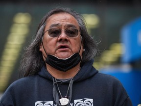 Maxwell Johnson, a Heiltsuk First Nation member who was arrested alongside his granddaughter as they were trying to open an account at the Bank of Montreal, stands outside the bank's main branch before a news conference, in Vancouver, B.C., Thursday, May 5, 2022.