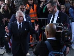 King Charles III greets members of the public queueing to see the Queen lying in state along the river Thames in Lambeth on Sept. 17, 2022 in London.