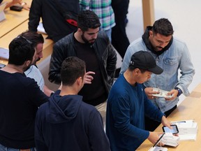 Customers shop at the Apple Inc. Fifth Avenue store in Manhattan, New York City.