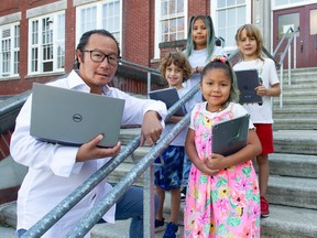 Lord Strathcona Elementary principal Jason Eng with students and their new computer equipment received through the Adopt-A-School campaign.