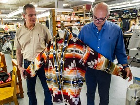 Behrouz Azizkhani, left, and Farid Rohani of Claymore Custom Clothiers with a Blood Tribe chief of police jacket that is being shipped to Manitoba. Uniforms for first responder from across Canada are made by hand by a workforce that come from around the world at Claymore in Vancouver, BC.